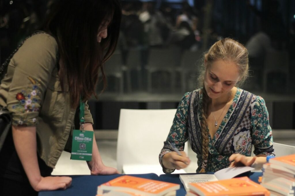 Ashley Dudarenok signing books as a keynote speaker