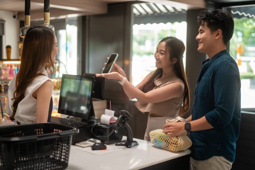 Customer making a mobile payment using a smartphone at a retail checkout counter.